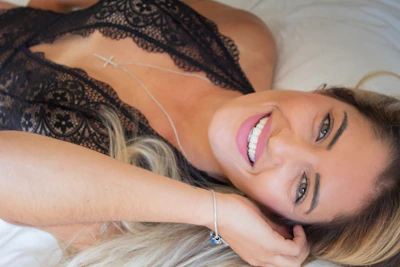 Jesse Roy relaxing comfortably in bed with a mischievous smile.