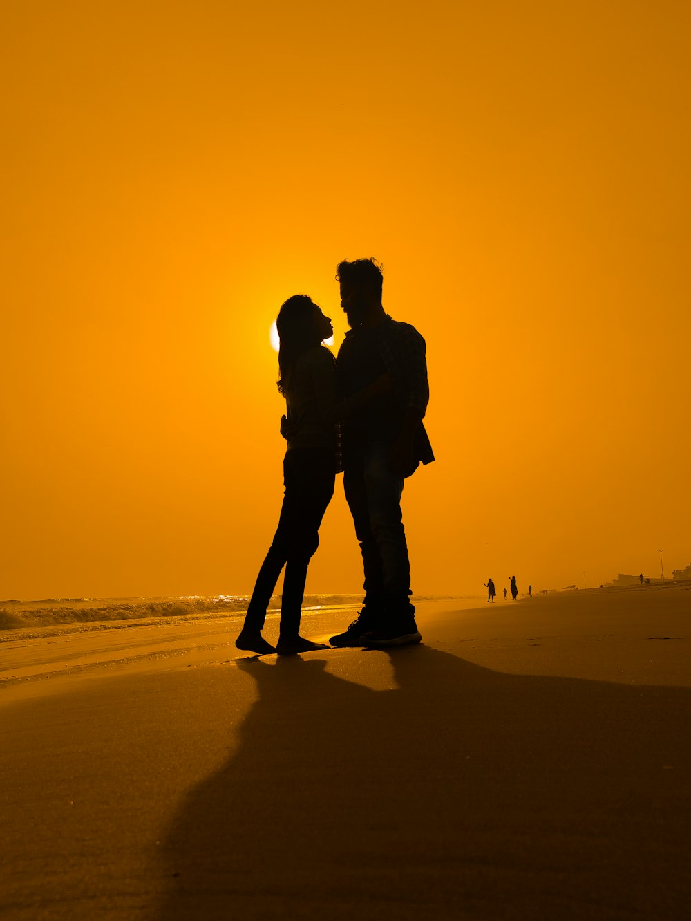 silhouette of man and woman kissing during sunset