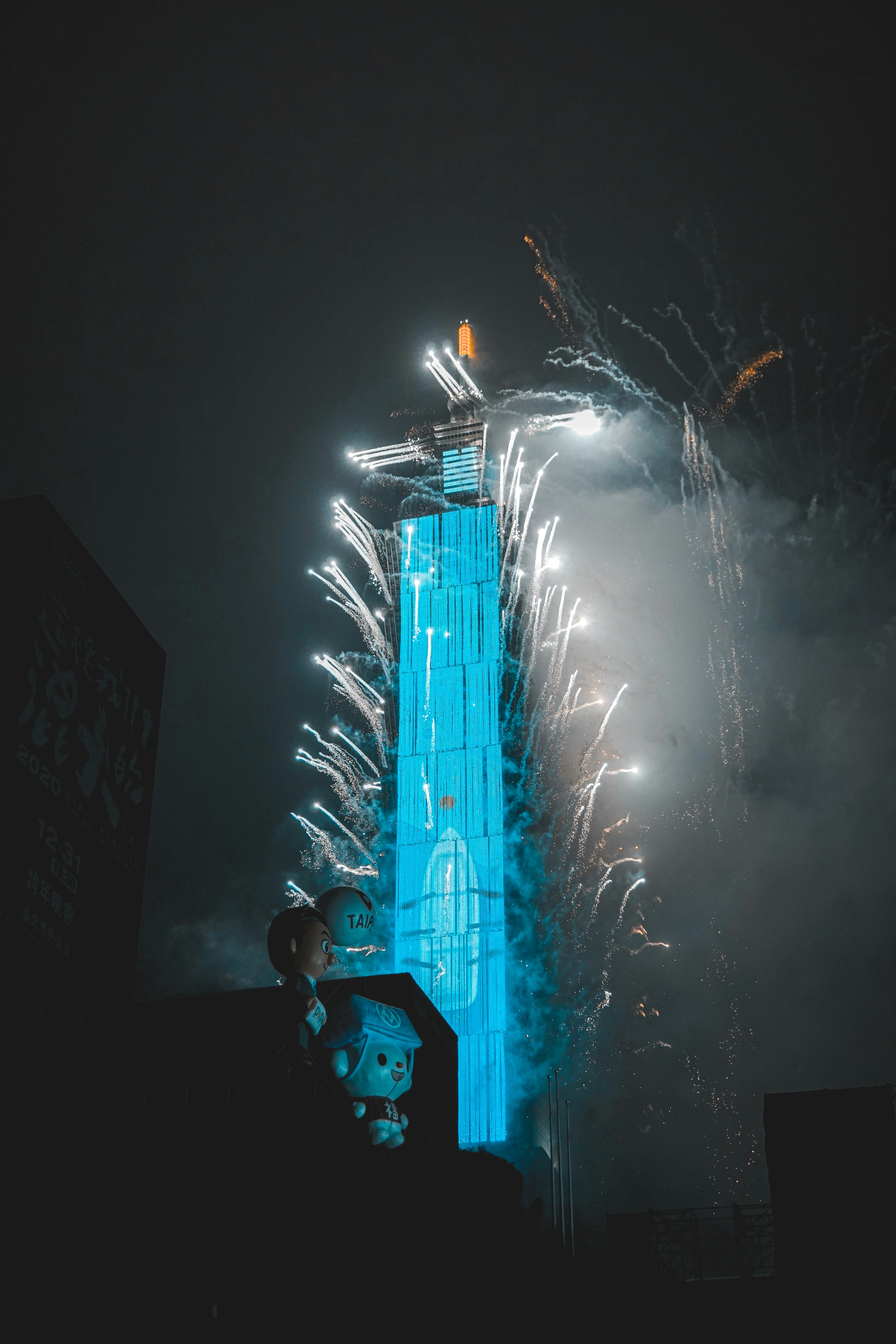 man in black jacket standing near white fireworks during night time