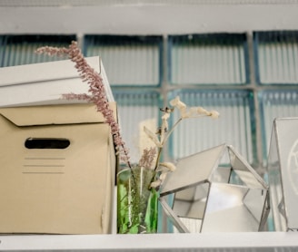 white cardboard box on white wooden shelf