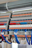 Automotive terminals and connectors displayed with wiring harnesses in a professional industrial setting.