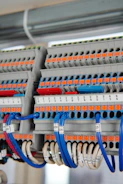 Automotive terminals and connectors displayed with wiring harnesses in a professional industrial setting.