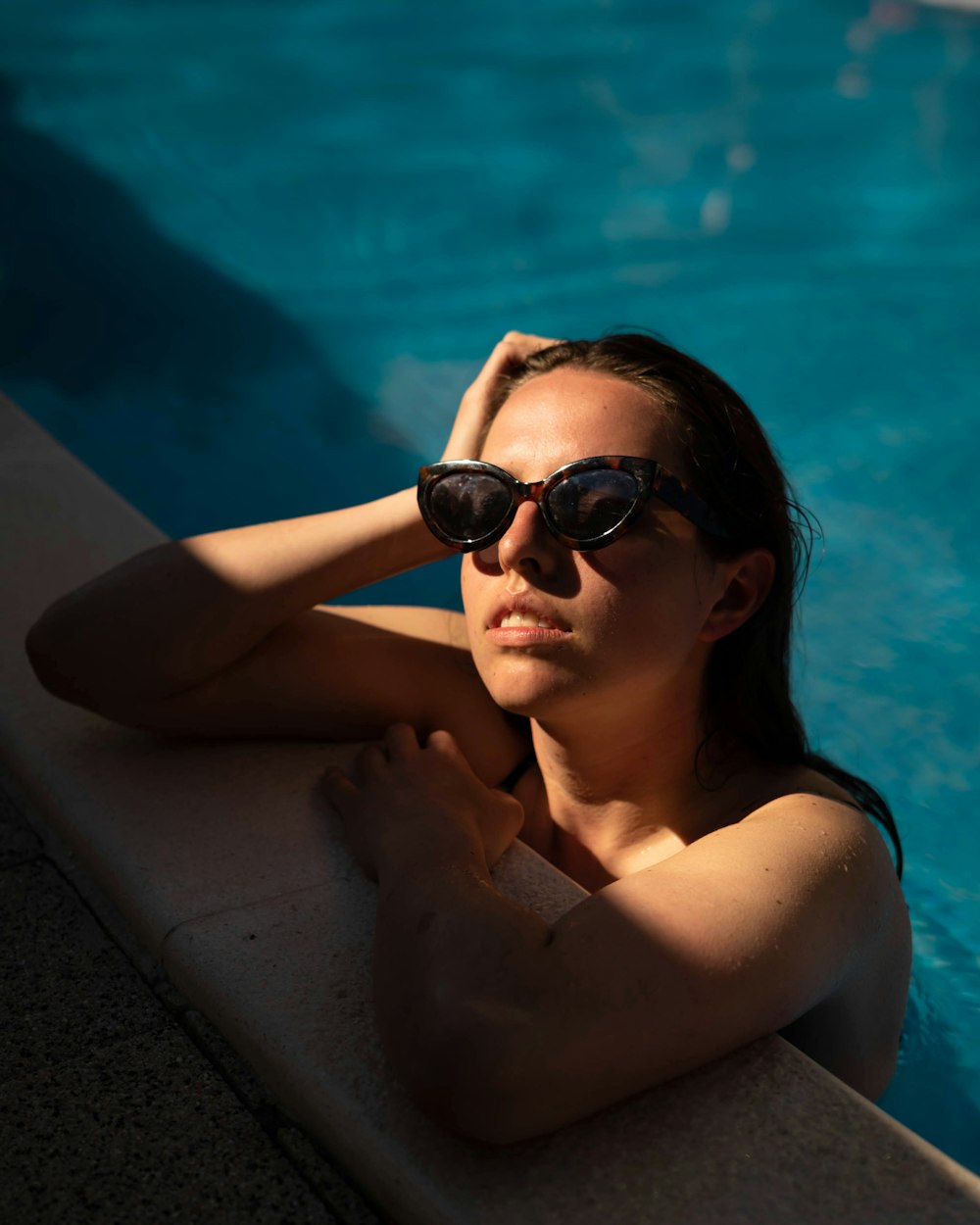 woman in black sunglasses sitting on swimming pool