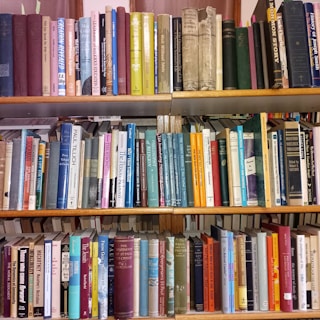 A bookshelf filled with various hardcover and paperback books.