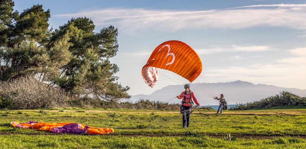 Personnes sur un champ d’herbe verte sous un ciel bleu pendant la journée