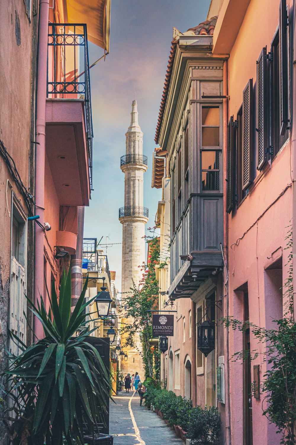 white concrete tower between brown concrete buildings during daytime