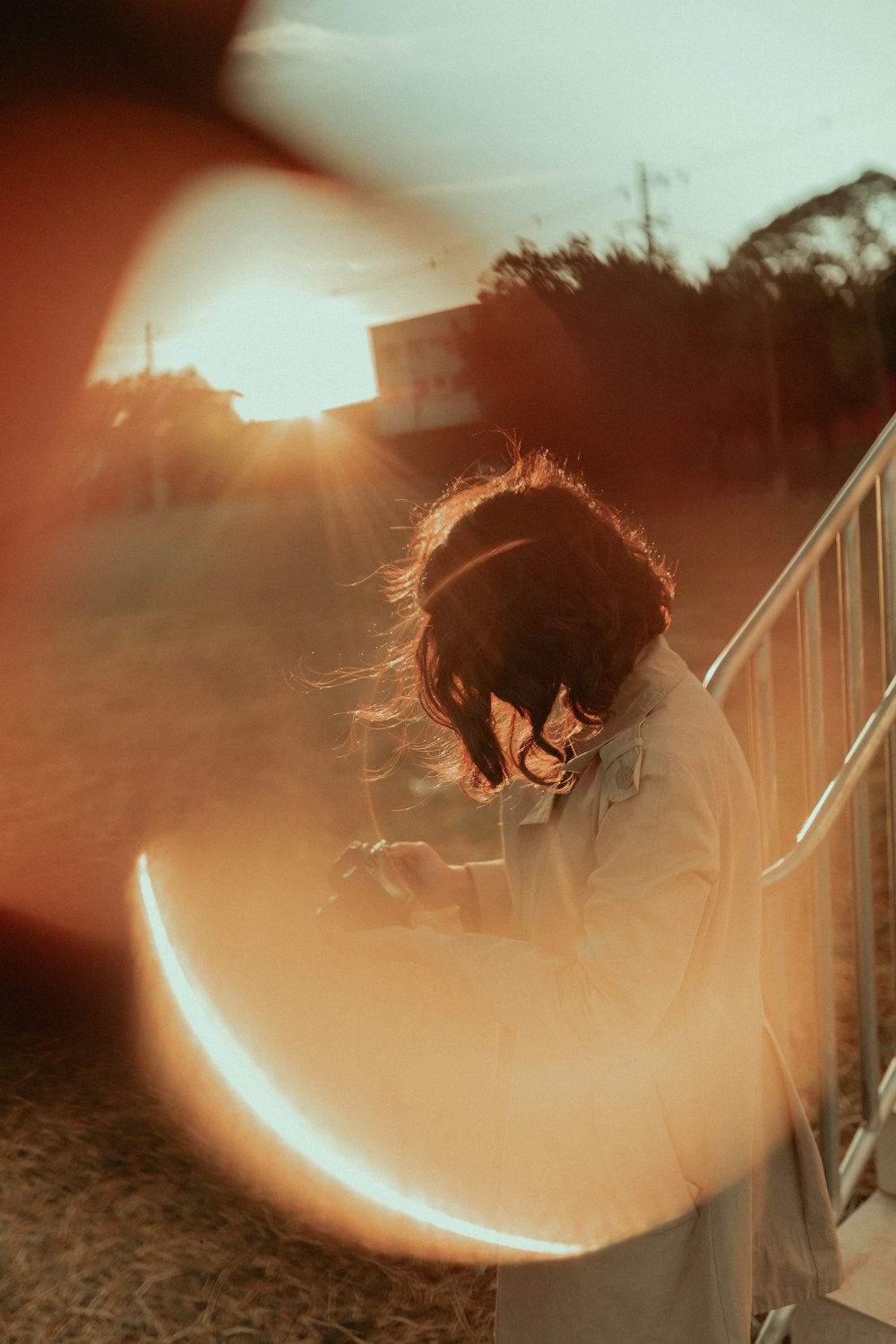 woman in white long sleeve shirt standing on balcony during sunset