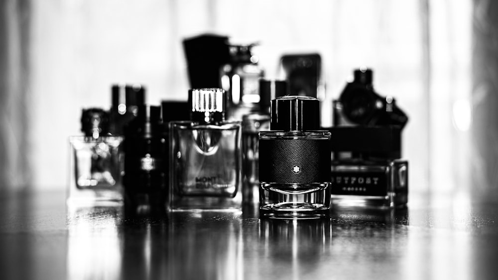 grayscale photo of perfume bottles