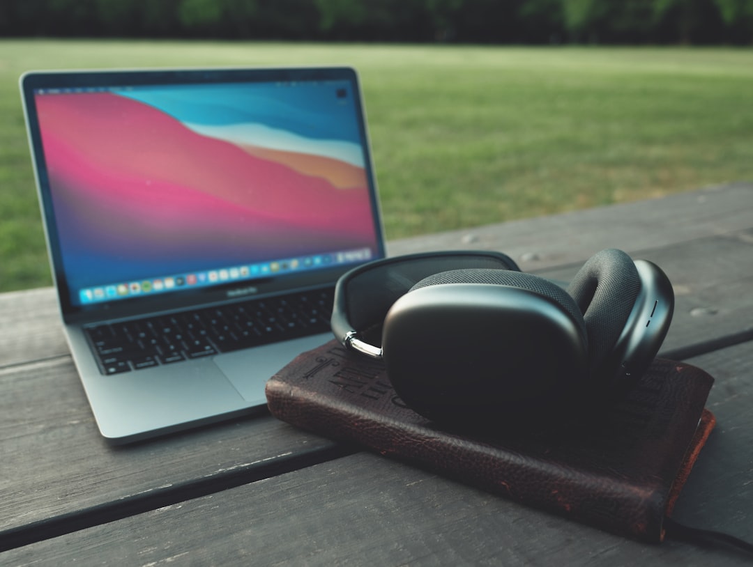 black headphones beside macbook pro