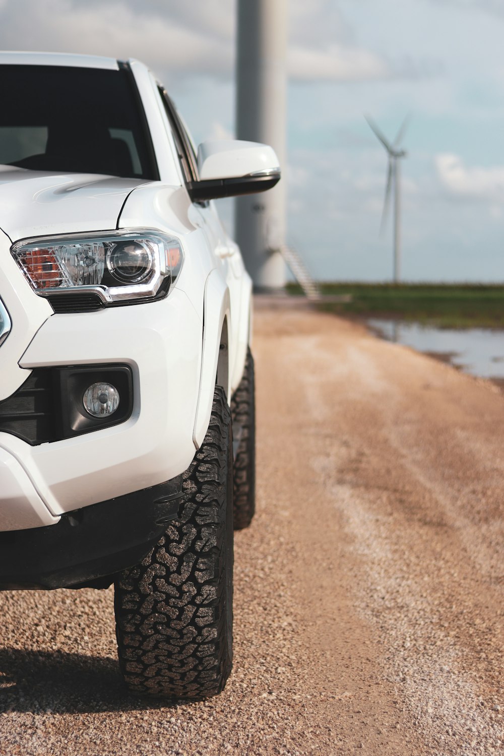 white car on brown dirt road during daytime