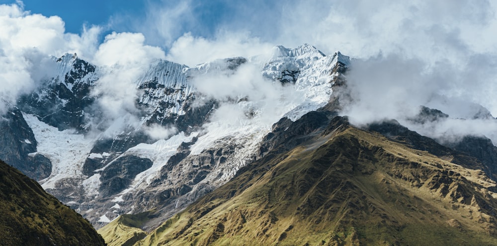 green and brown mountain under white clouds and blue sky during daytime