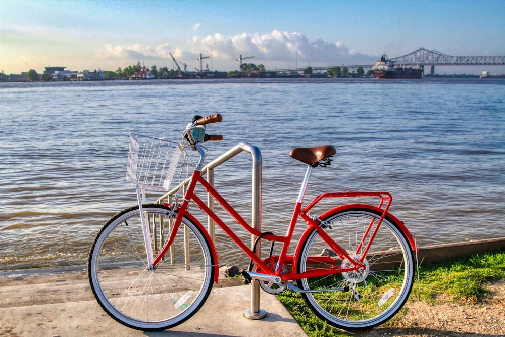 red city bike near body of water during daytime