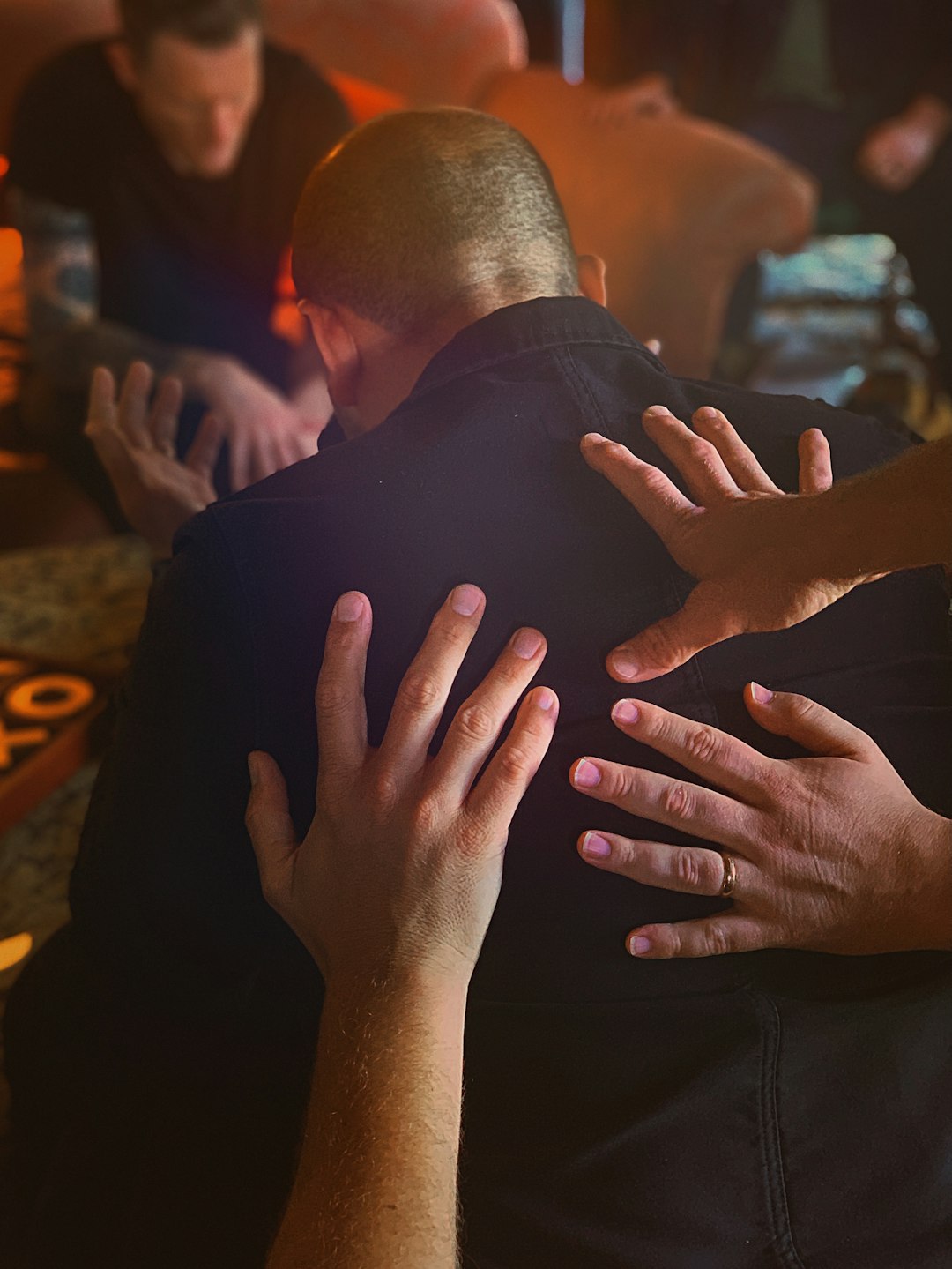 man in black shirt covering face with both hands