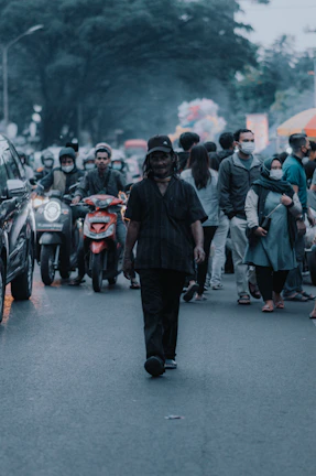Dynamic shot of a group wearing layered fusion streetwear with gold highlights, walking confidently on a busy Karachi street.