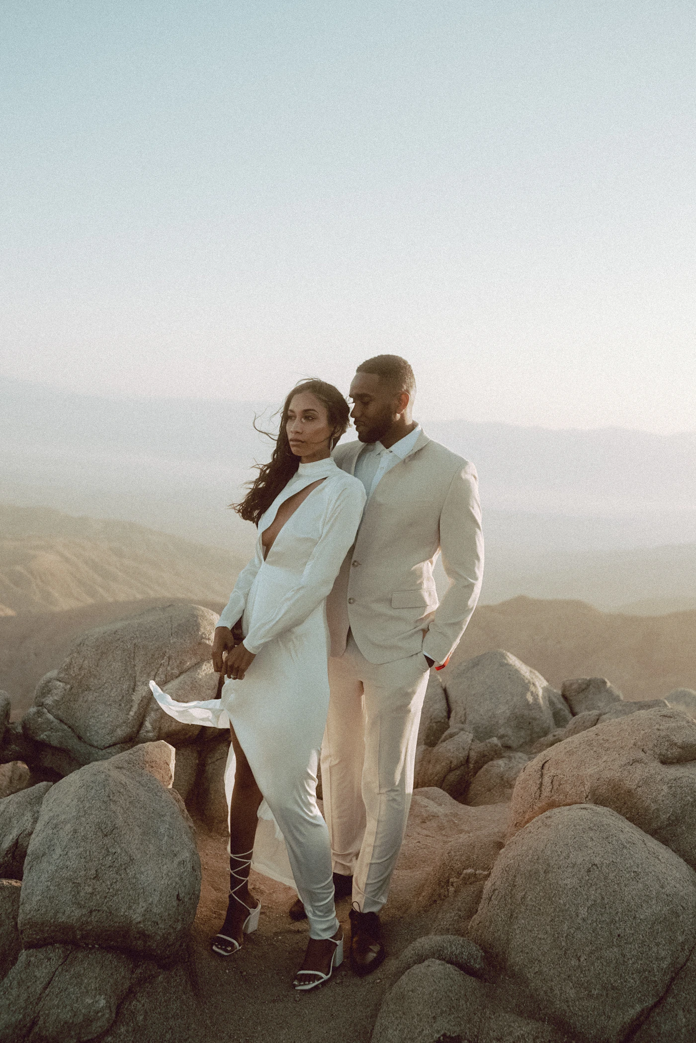 Intimate couple outdoors on rocky terrain in a minimal elopement or small wedding setting with vast natural landscape