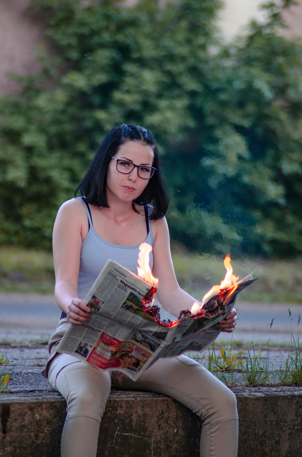 woman in white tank top sitting on brown wooden chair holding book