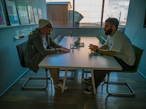A recruiter from Talentbridge discussing candidate profiles with a client in a cozy meeting room.