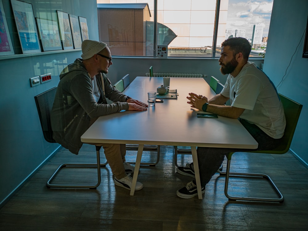 man in black jacket sitting beside man in gray jacket