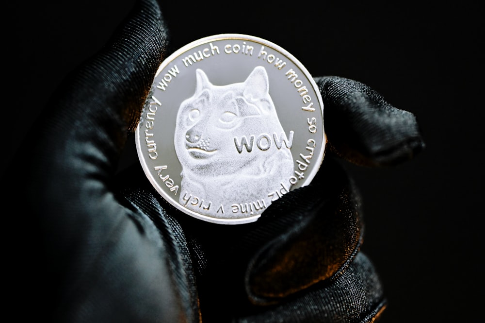 silver round coin on black textile