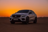white bmw m 3 coupe on brown sand during sunset