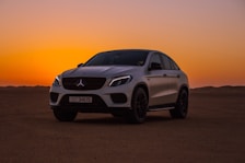 white bmw m 3 coupe on brown sand during sunset