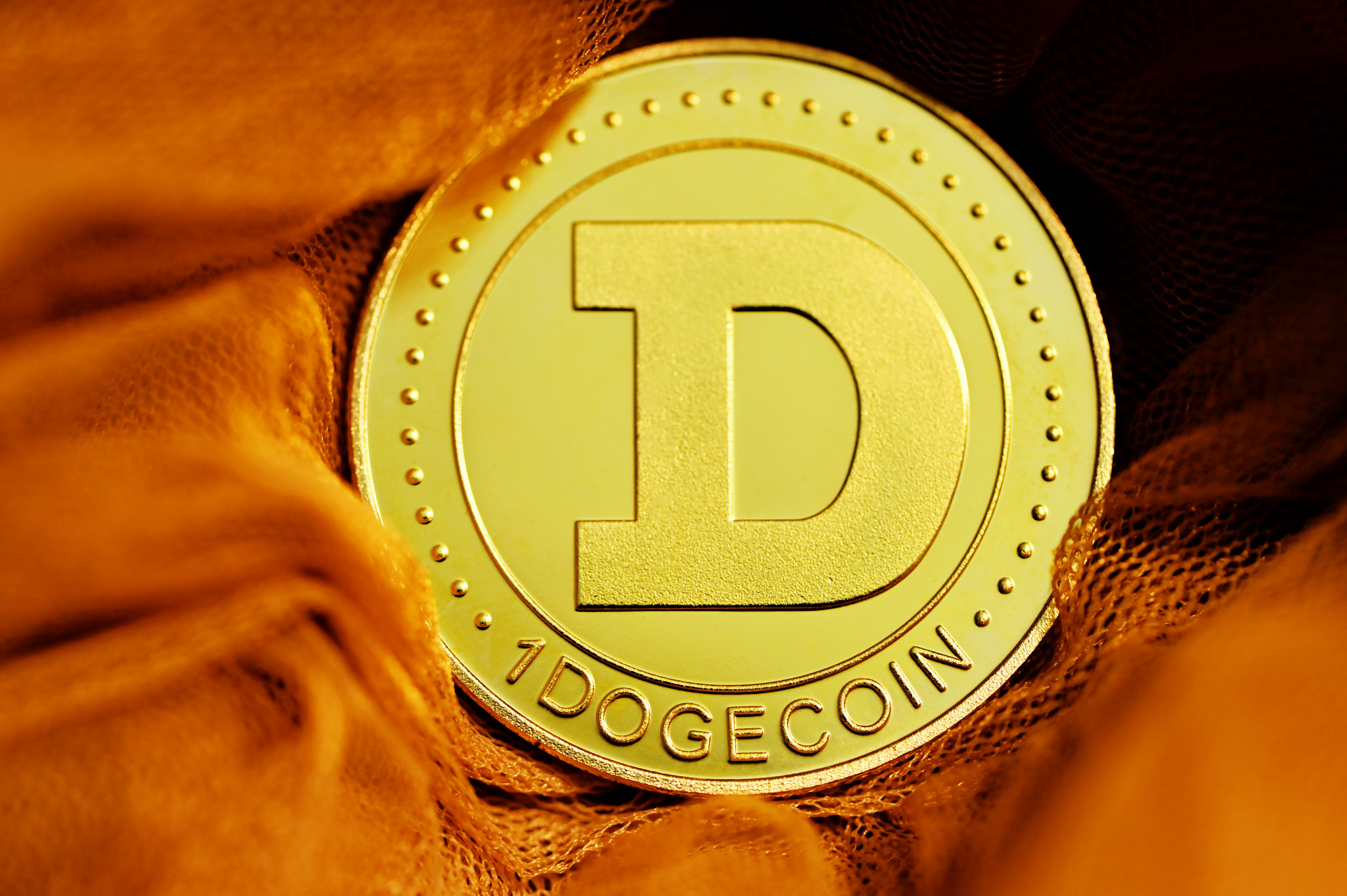 A single Dogecoin covered by orange fabric.