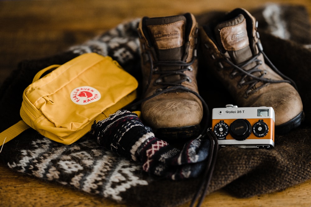 brown leather boots beside yellow plastic bag