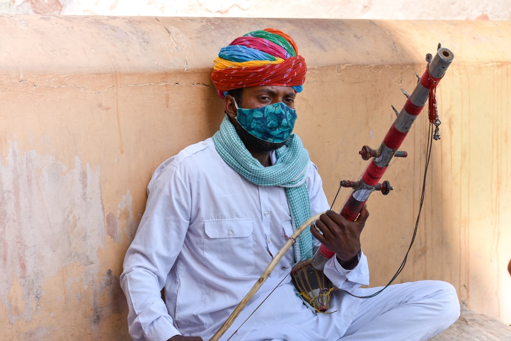 man in white thobe holding black and brown stick