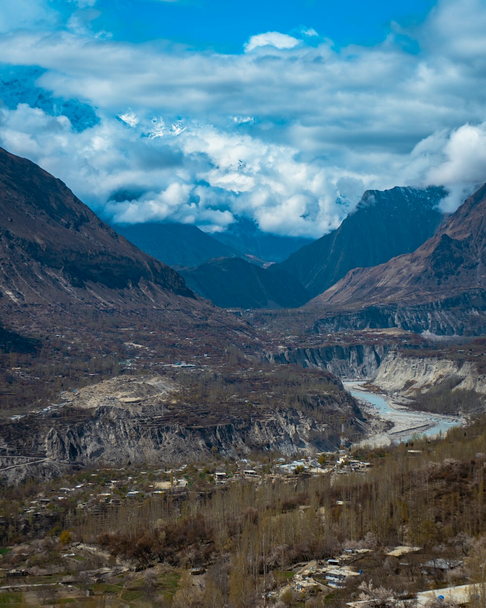 Montañas marrones y verdes bajo nubes blancas y cielo azul durante el día