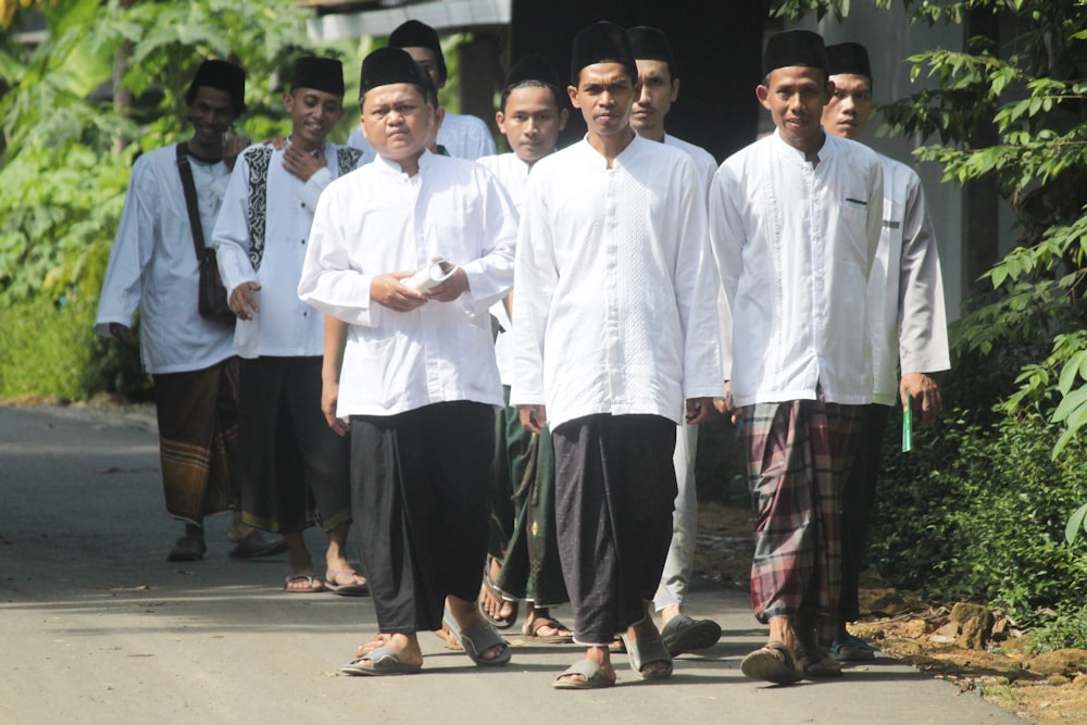 group of men in white dress shirt and black pants standing on gray concrete floor during