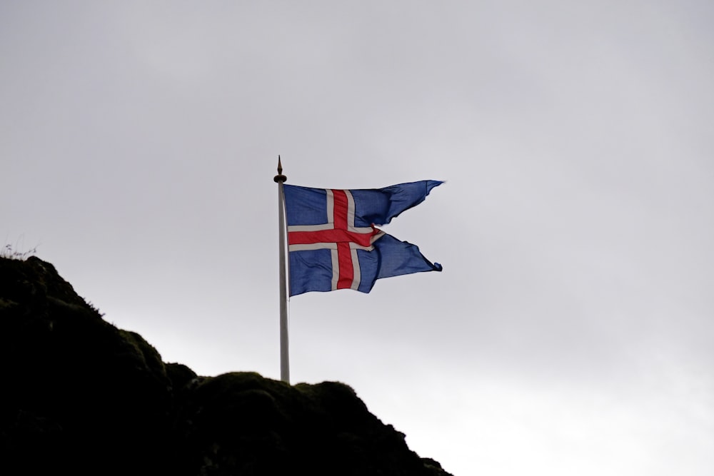 blue white and red flag on top of mountain during daytime