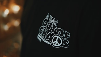 a person wearing a black shirt with a peace sign on it