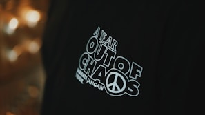 a person wearing a black shirt with a peace sign on it