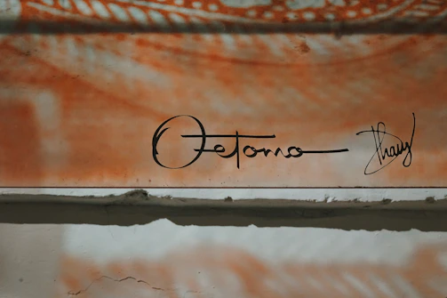 Randy signing the finished original artwork with charcoal brush strokes.