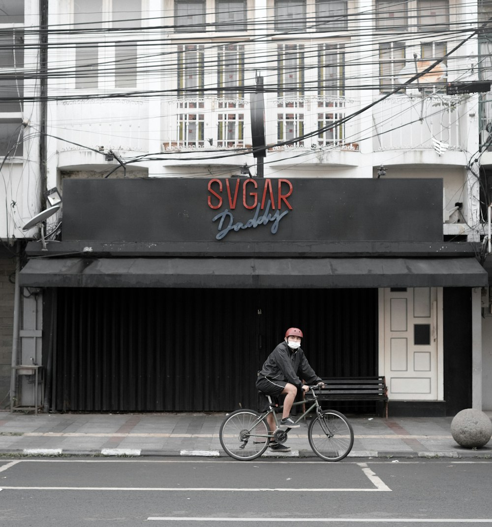 man in black jacket riding bicycle on road during daytime