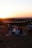 A group enjoying a picnic with stylish camping chairs at sunset.