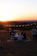 A joyful couple sharing a beautifully set long-table feast outdoors at sunset.