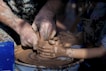 person making clay pot with clay