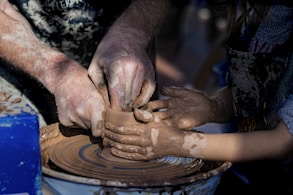 person making clay pot with clay