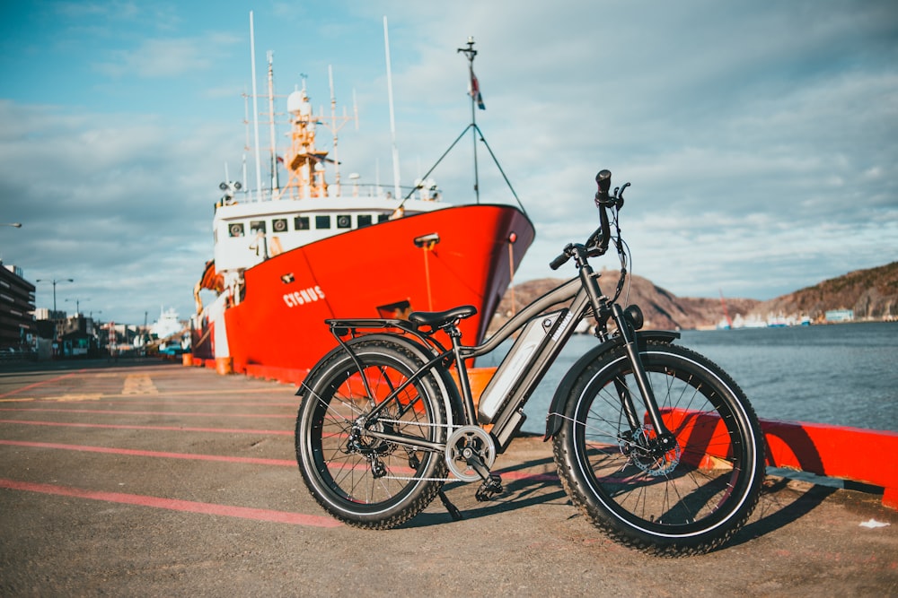 red and white cruiser bicycle on brown sand near body of water during daytime