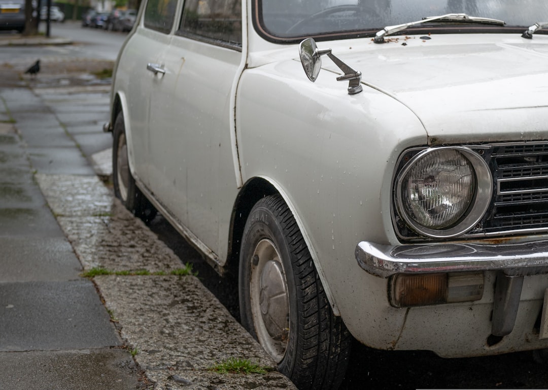 white car parked on gray concrete pavement