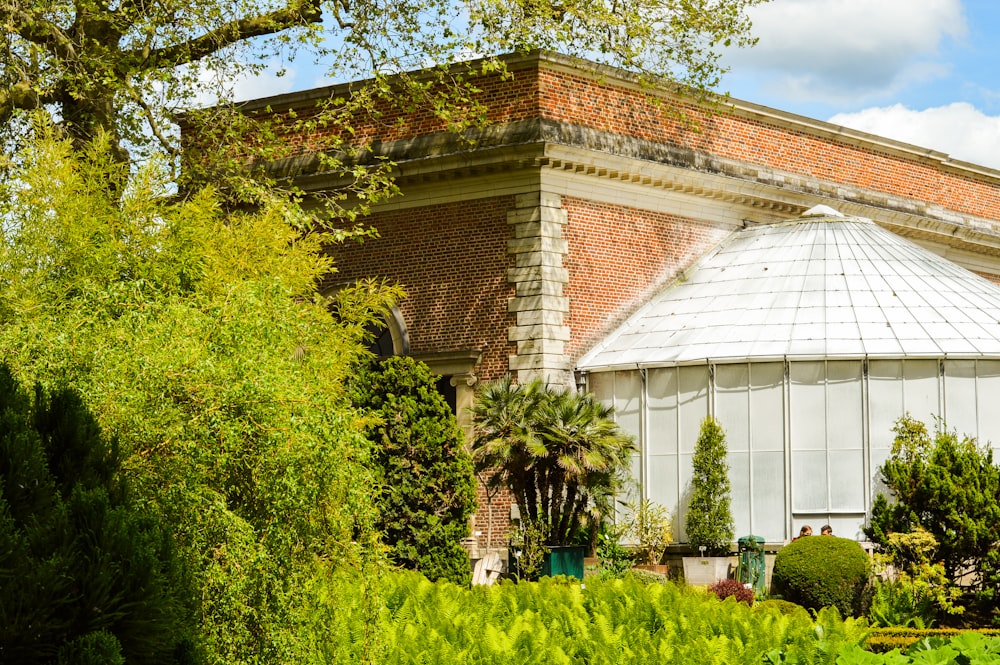 Maison en béton brun et blanc près d’arbres verts pendant la journée