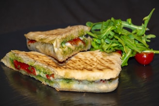 panini à base de pesto, fromage et jambon avec des la salade à coté 