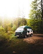 Scenic outdoor shot of a remodeled van parked in a lush green forest