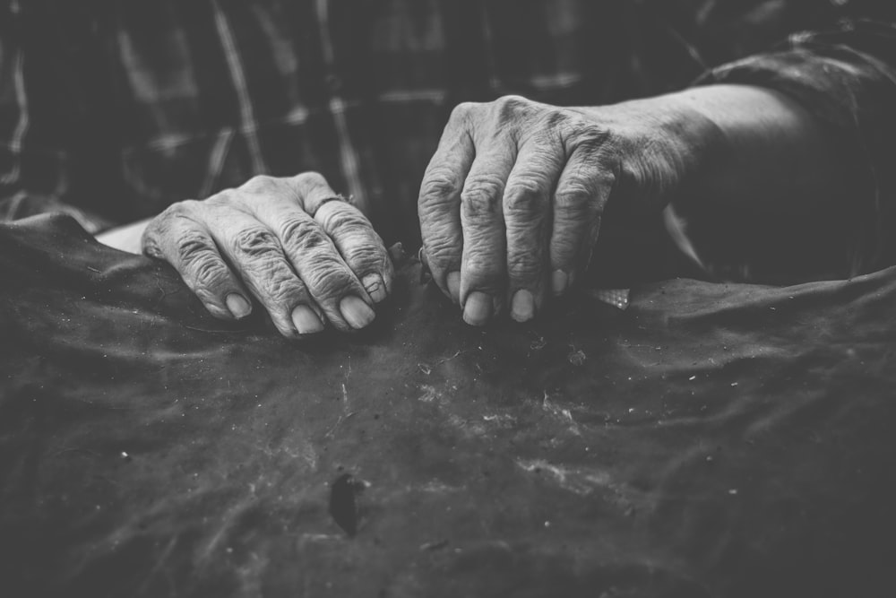 grayscale photo of persons hand with rings