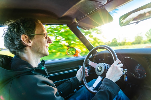 Person wearing polarized sunglasses while driving, with a clear view of the road and reduced glare.