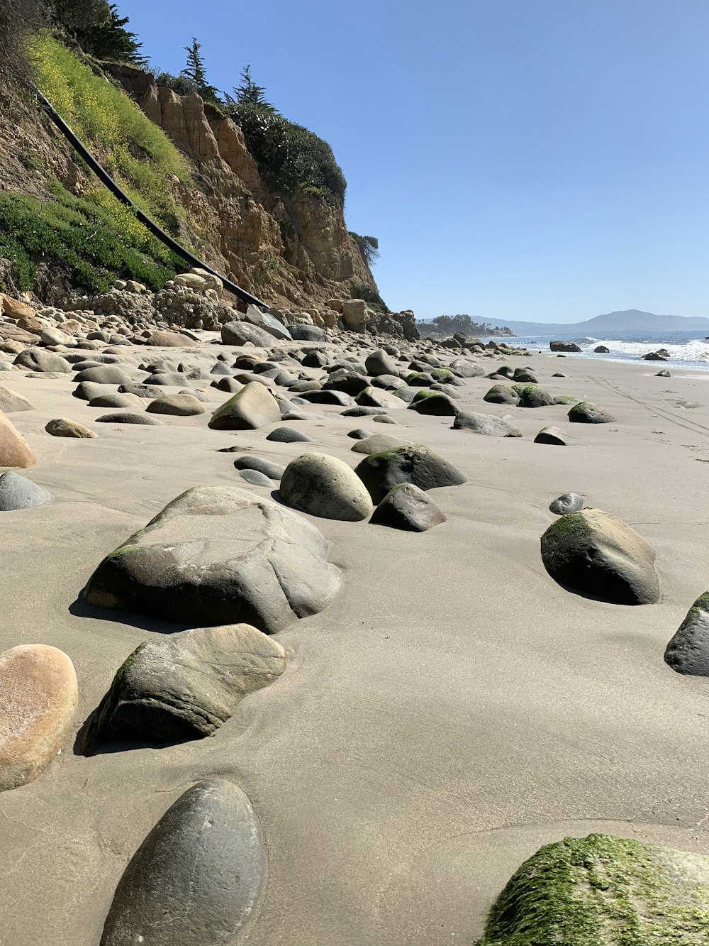 Schwarze und weiße Steine am Strandufer tagsüber