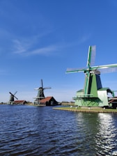 windmill near body of water during daytime