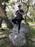 Kids balancing on one foot in a sunny outdoor yoga class.