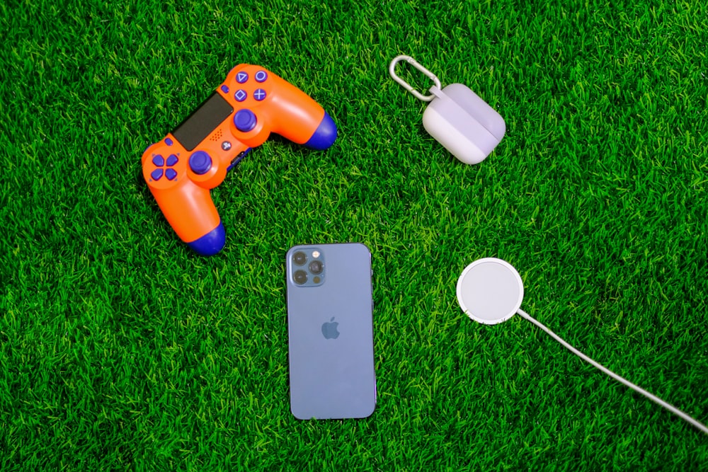 prata iphone 6 ao lado do controlador de jogo laranja e azul